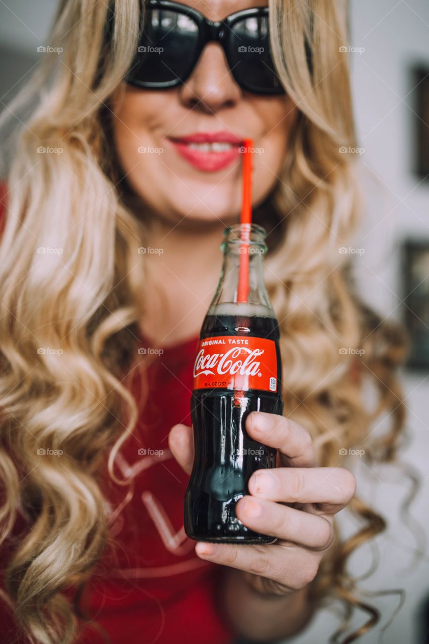 Girl holding Coca Cola bottle 