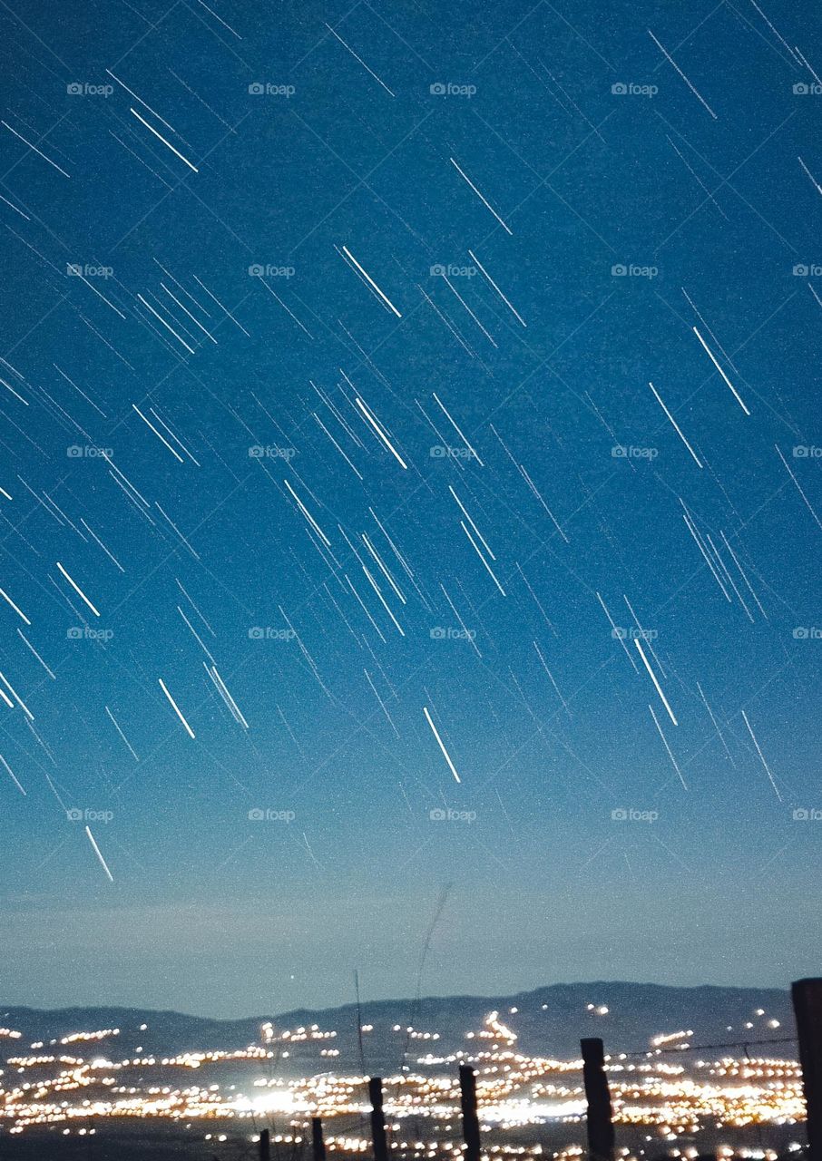 Long exposure that forms the trace of the star, in a blue sky at the top of the mountain