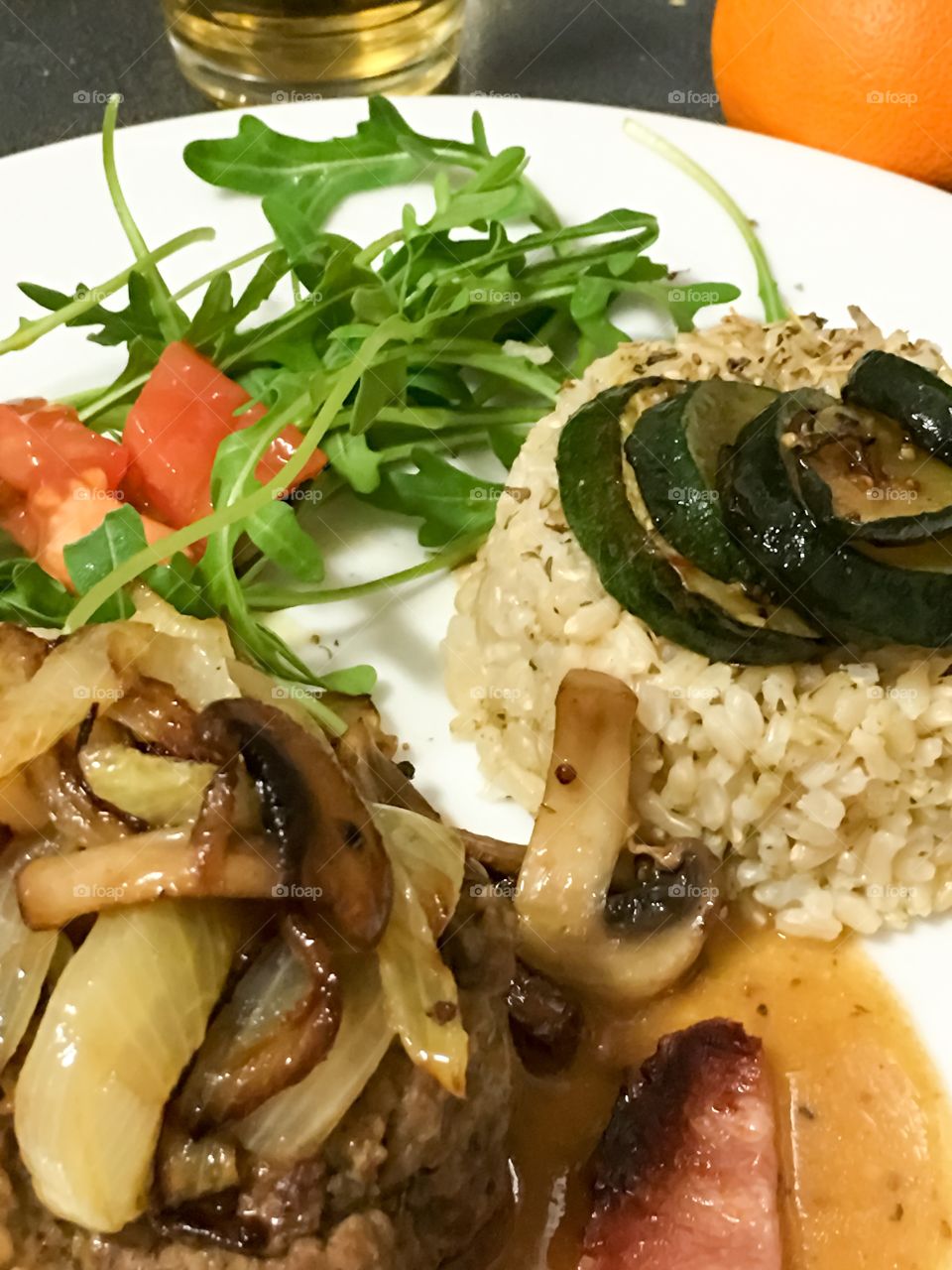 Salisbury steak with sautéed mushrooms Carmelites onions, zucchini topped bed of rice, with side salad 