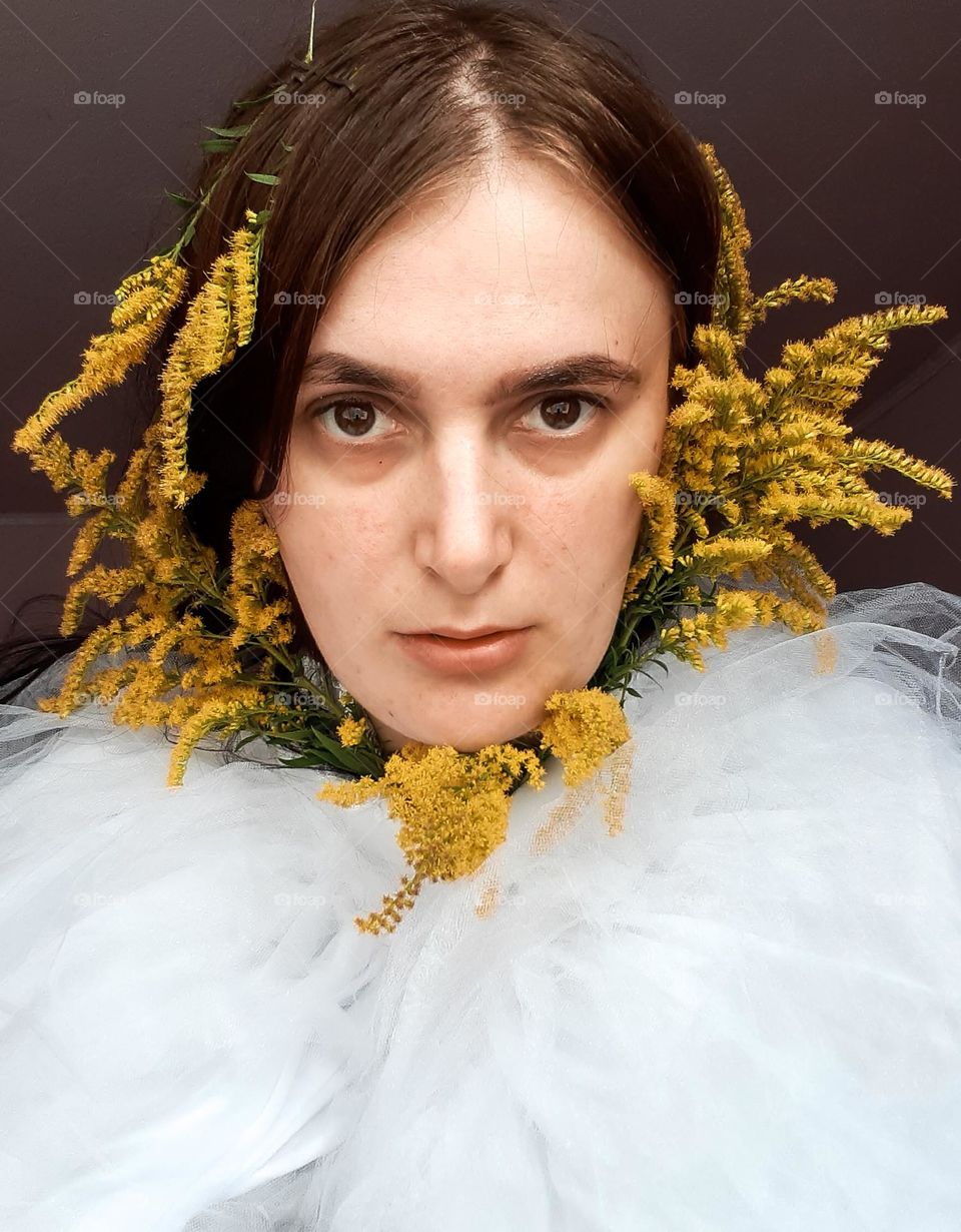 Portrait of an angry girl with yellow flowers