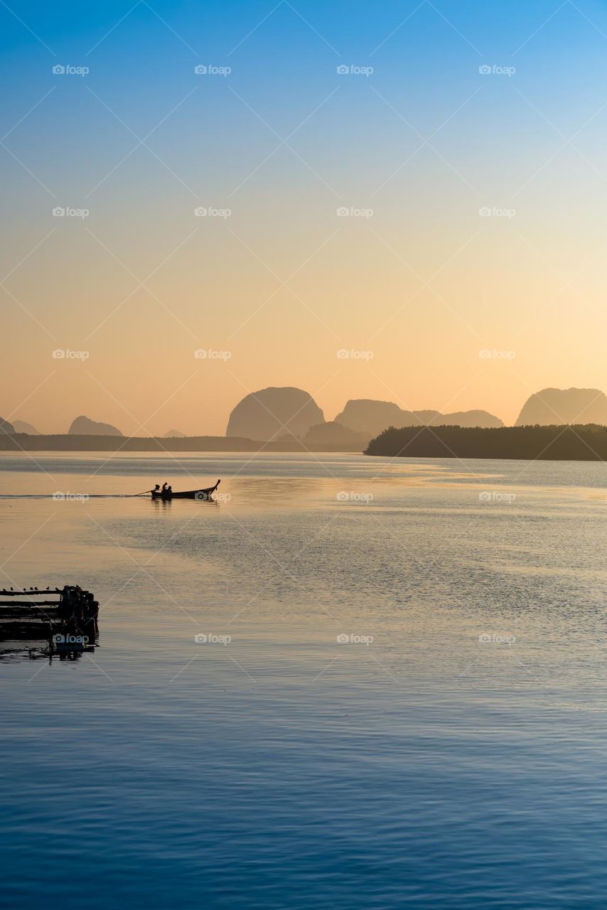 Beautiful Sunrise moment above silhouette of boat in sea