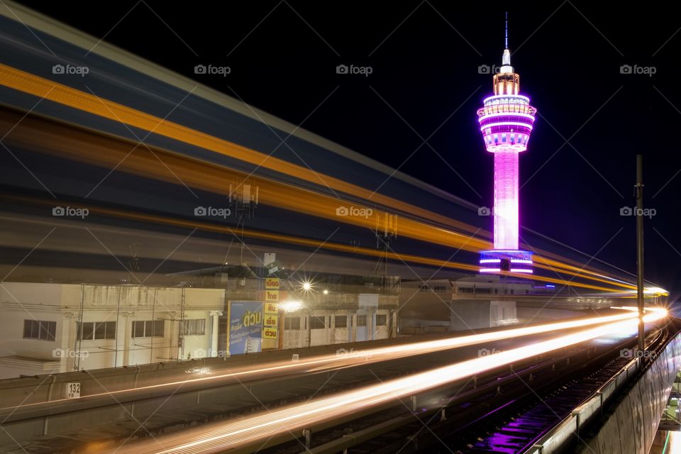 Light of Electric train BTS when reach to station on beautiful background of City tower of Samut Prakan province,Thailand