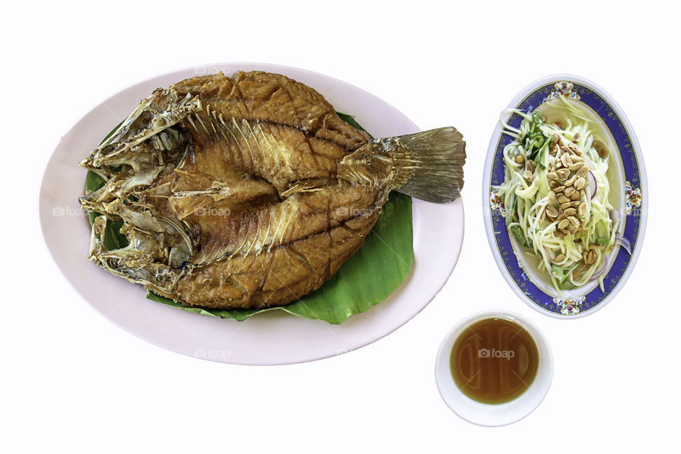 Isolated fried snapper fish With seafood sauce and vegetables  in dish on a white background with clipping path.