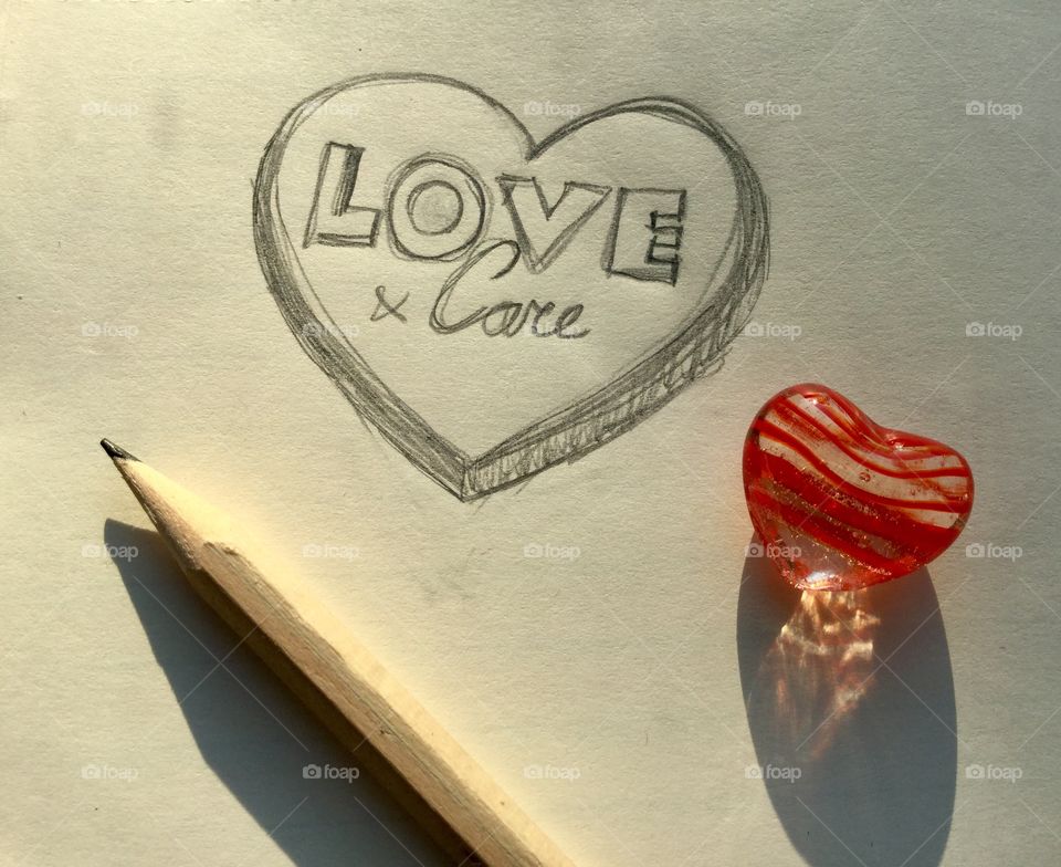 Hand drawn heart, love & care. With pencil and a glass heart.