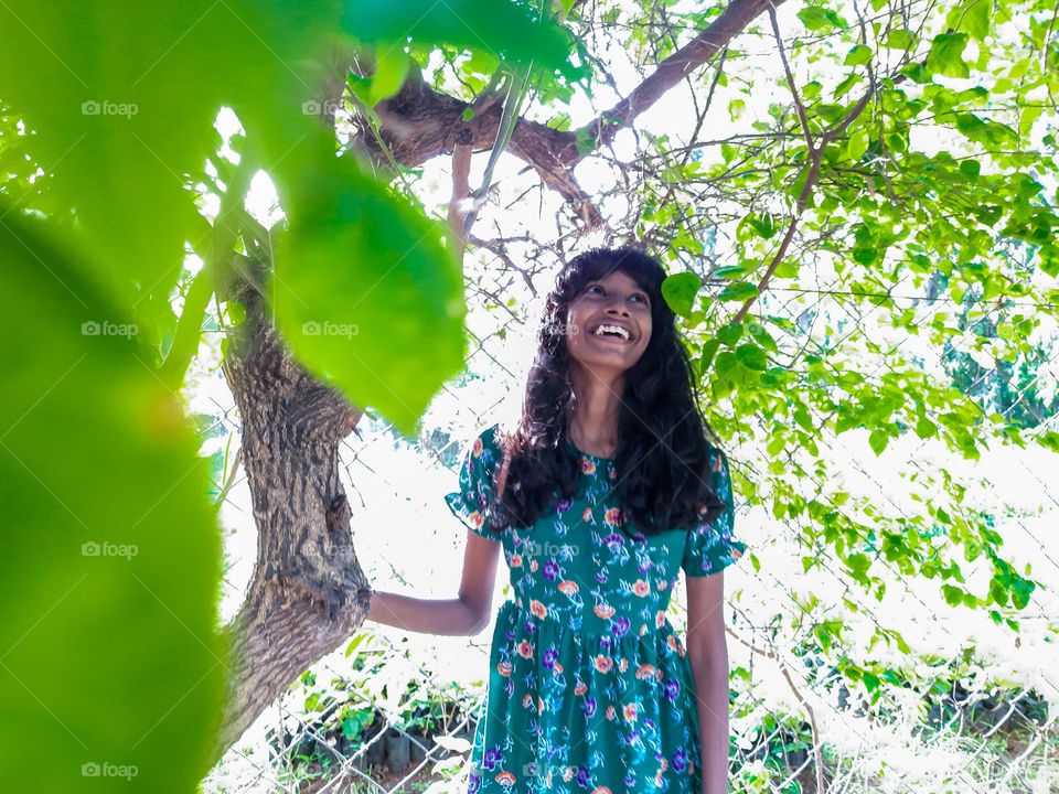 A girl standing near a tree