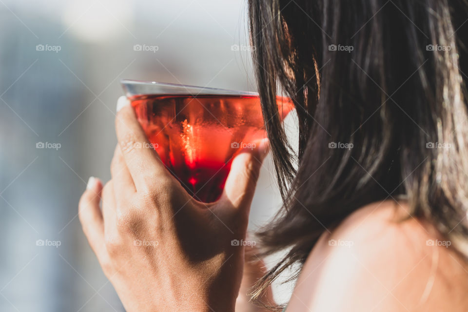 Woman drinking cocktail in the bar during happy hour