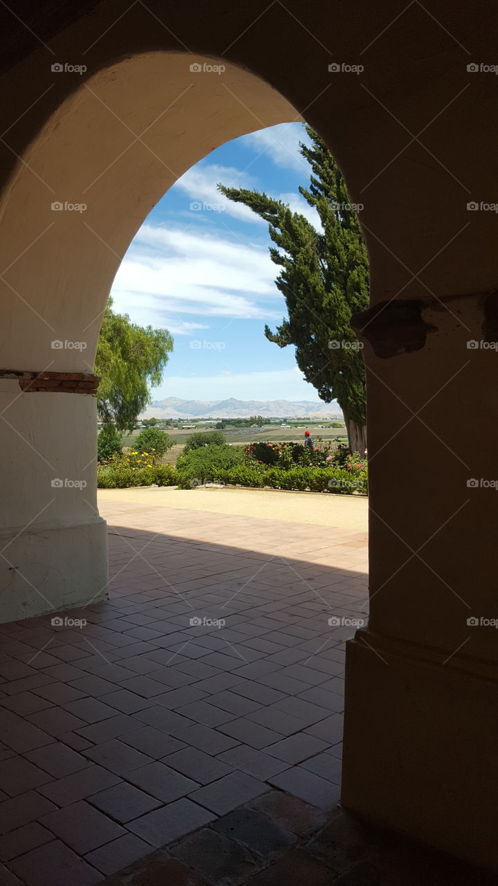 From under the shade of the arches of the Mission San Juan Bautista, I have a beautiful view of farmland on the valley floor.