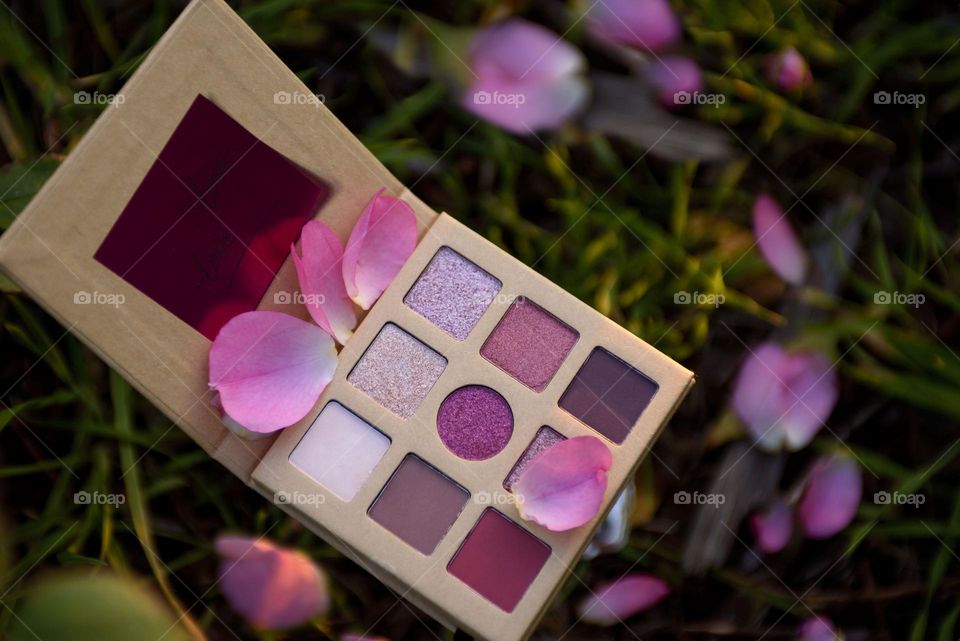 Eye shadow palette on floral background.