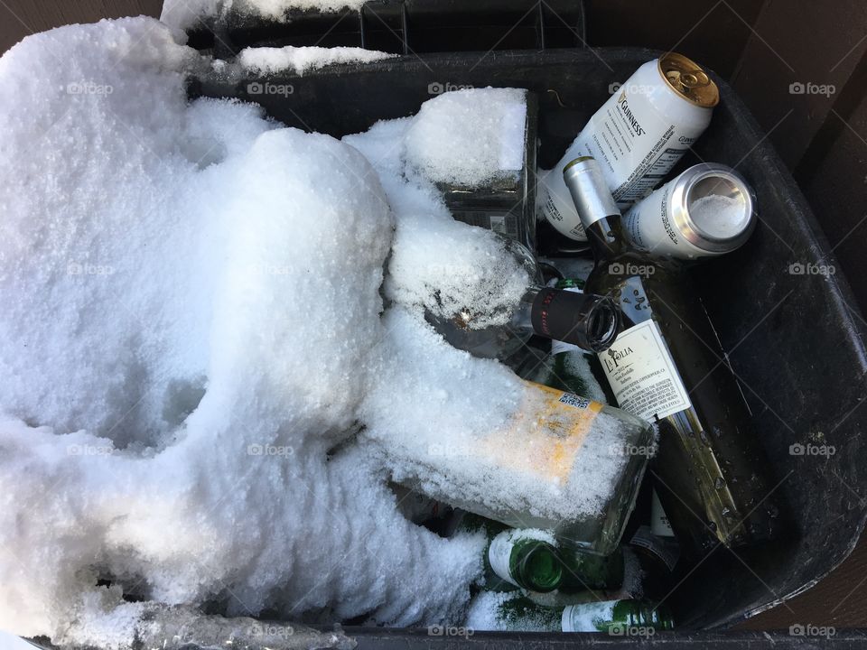 Trash of wine bottles cover with snow