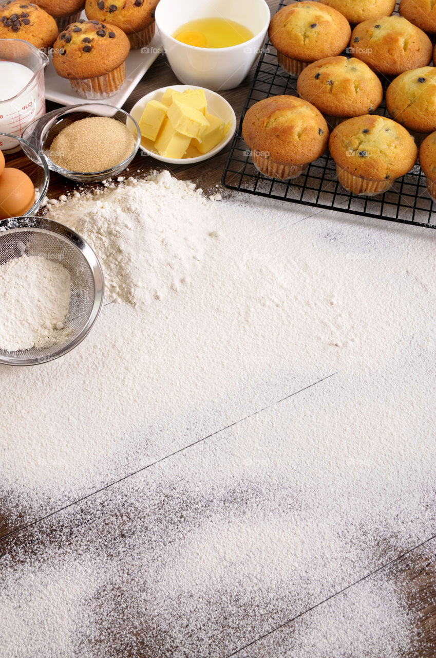 Muffins next to a table full of flour
