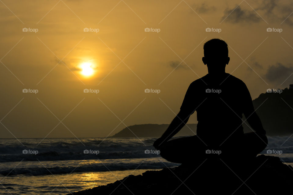 Meditation on a beach at sunset