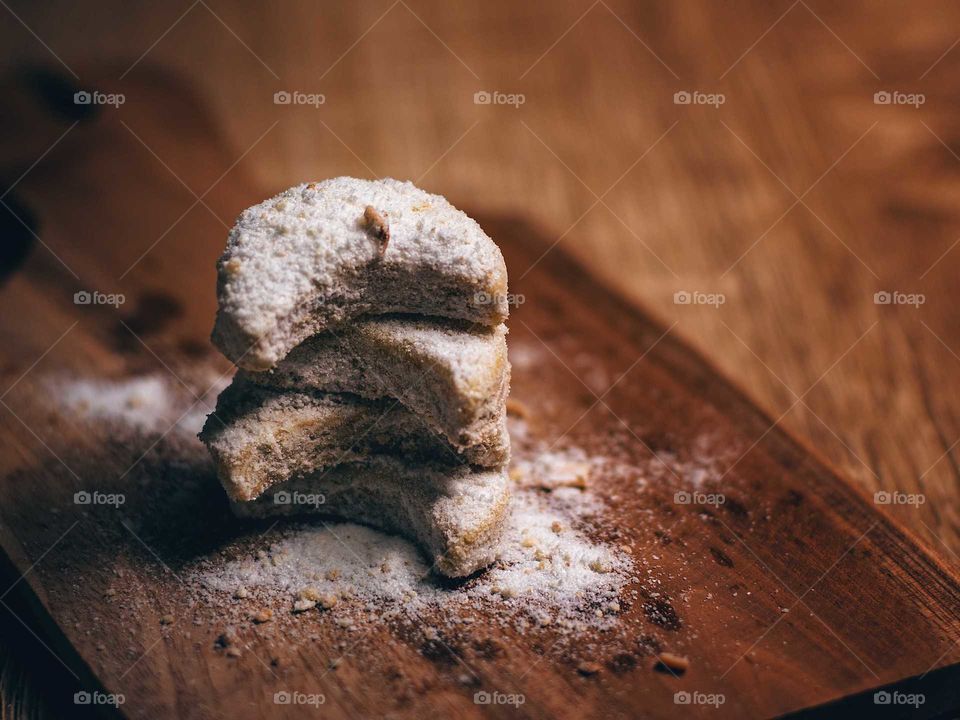 Three Crescent Shaped Cookies on top of cutting board.