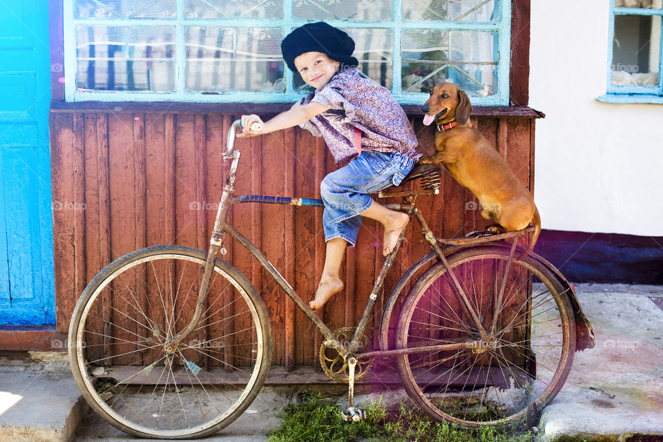 Boy and dog sitting on the rusty bicycle
