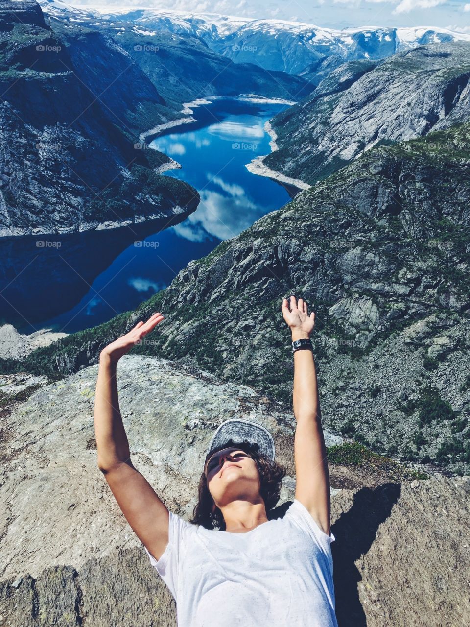 Happy girl on the top of Trolltunga rock above Geirengerfiord in Norway.  