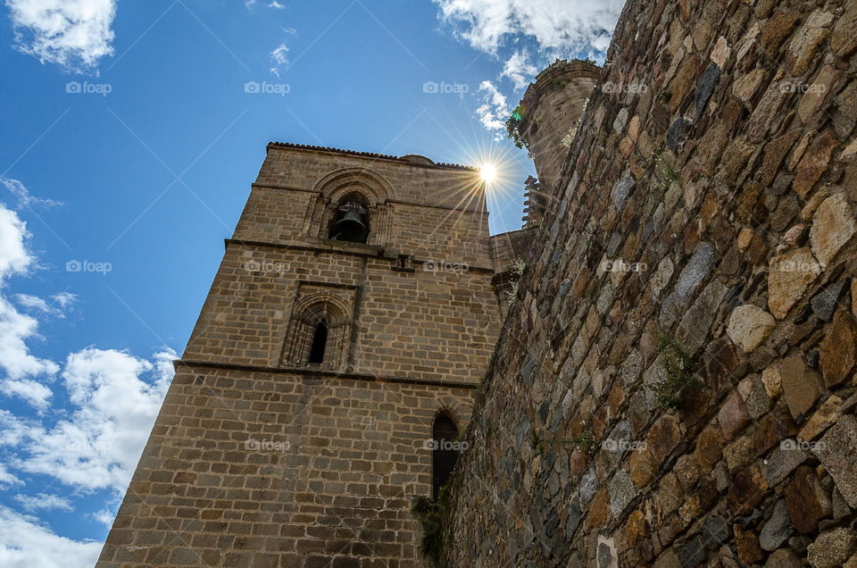 The sun rises over the bell tower of an old church