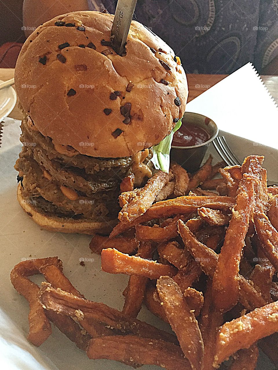 Triple burger with delicious sauces and sweet potatoes fries