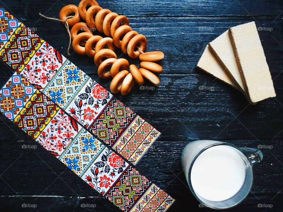 cakes, a cup of milk, bagels and waffles on a black background