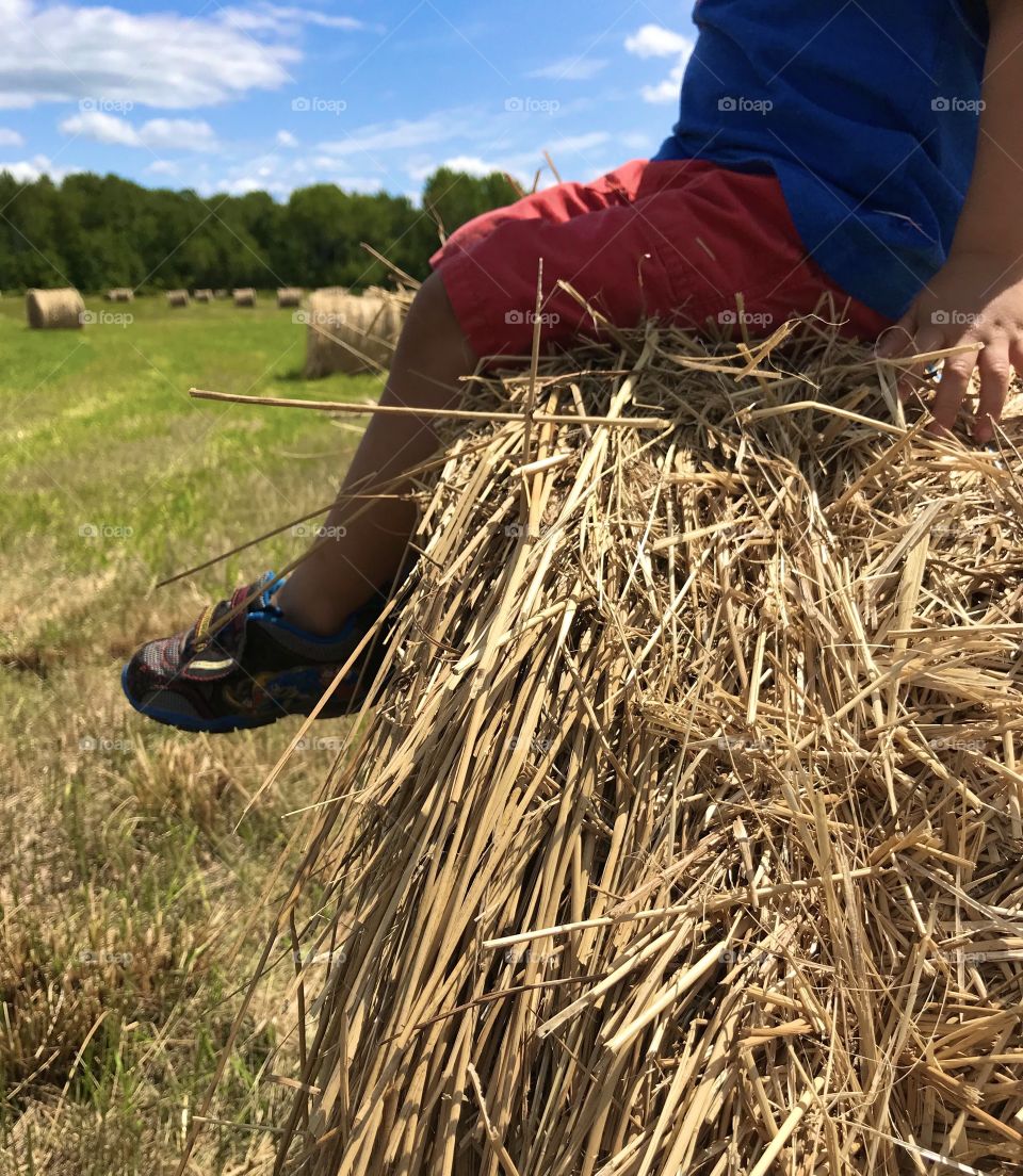 Child sitting on a hay bail
