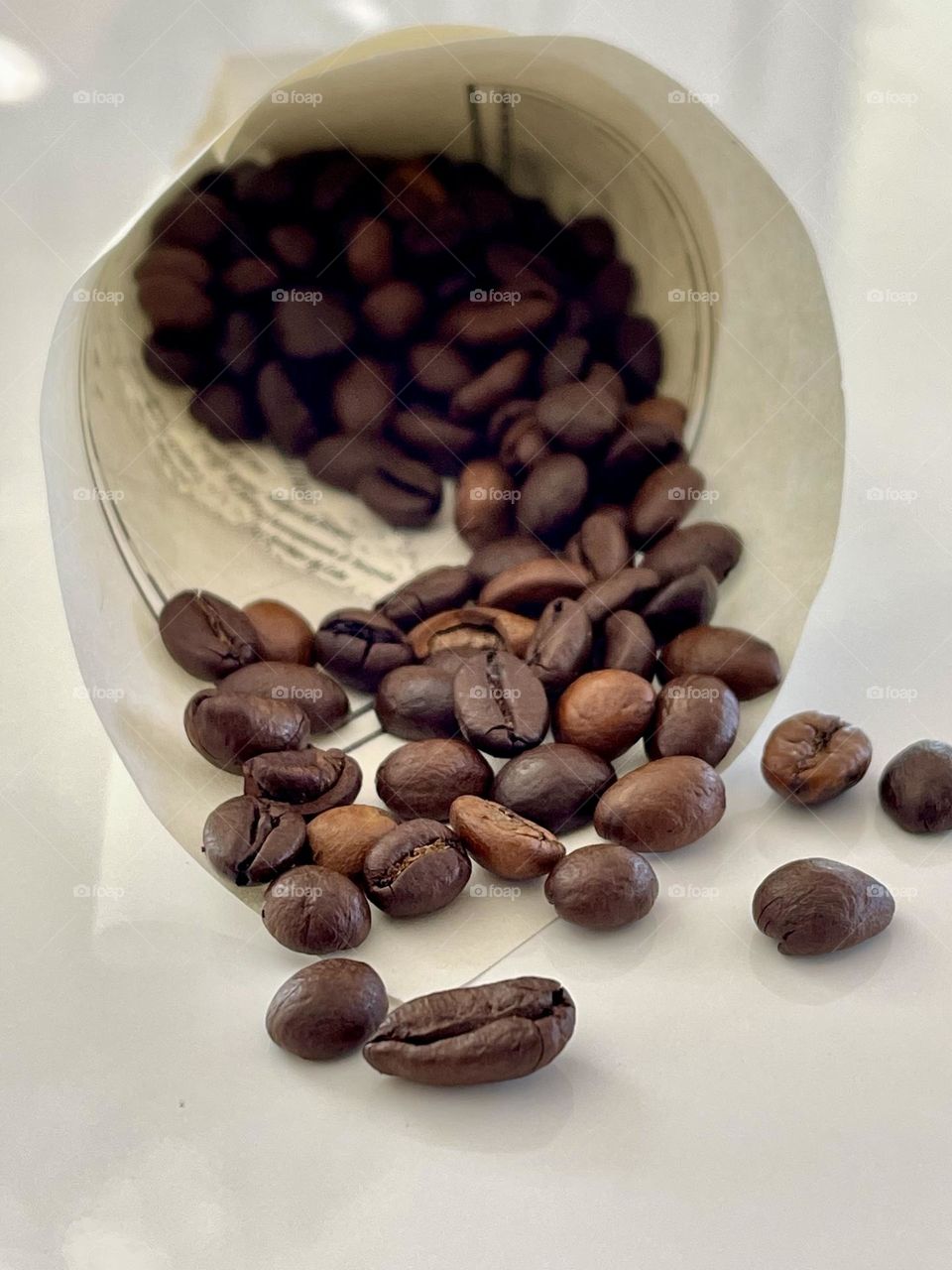 cornucopia or paper cone made with a map printed book page, and coffee beans emerging from it 