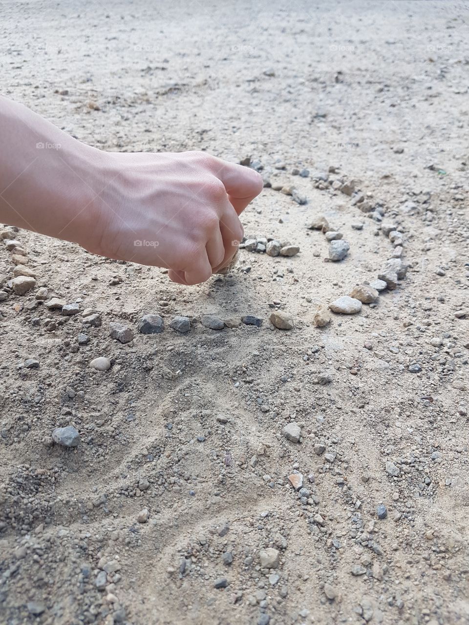 kids hand with little stones