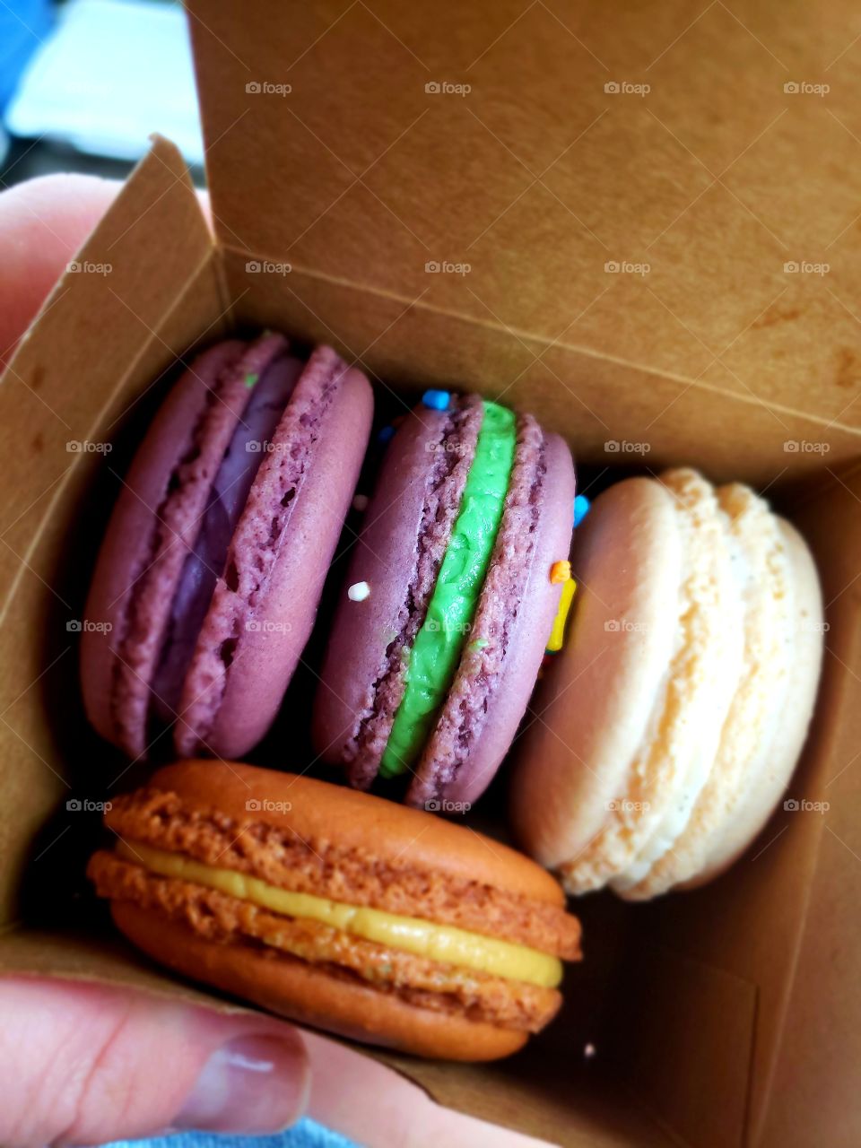 Box of four assorted colorful French macarons.