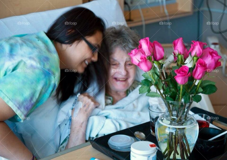 Visiting grandma . Granddaughter visiting grandma in hospital , Birthday celebration .