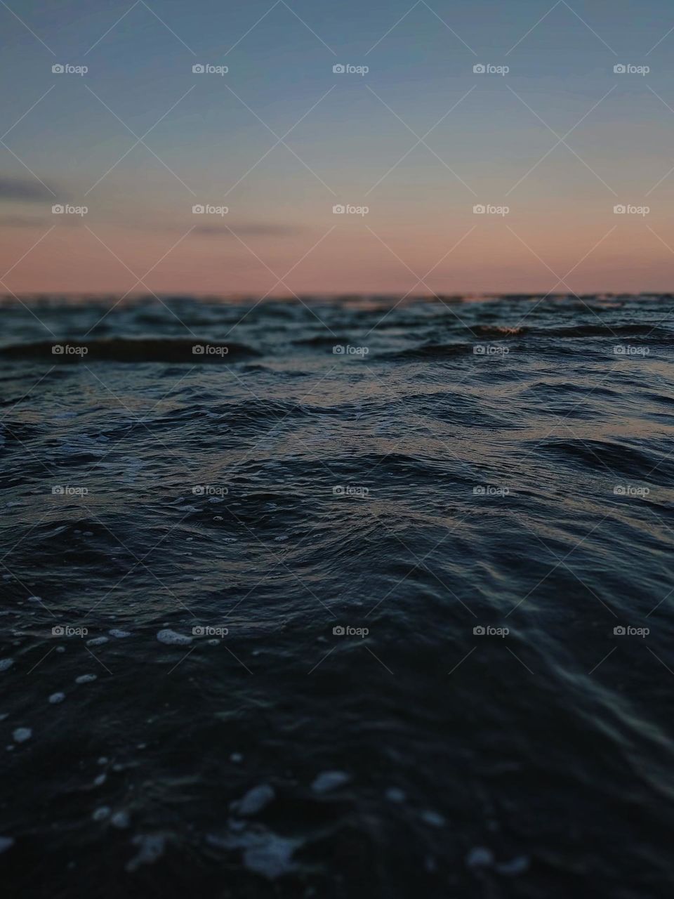 The rough surface of the water in the warm light of the sea sunset.