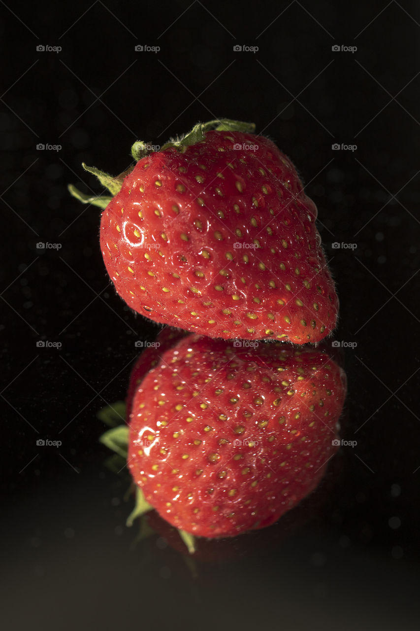 A strawberry and its reflection
