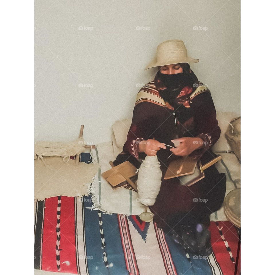 A craftswoman in her workshop specialized in making traditional textiles
She uses manual means
In this scene she is spinning wool