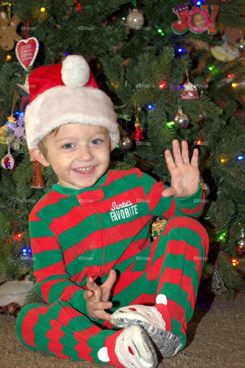 A little boy in front of Christmas tree