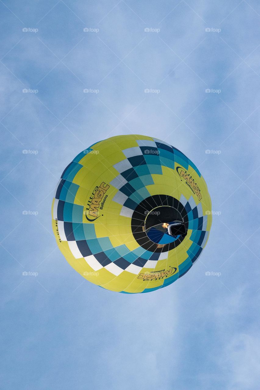 Laying on the grass looking up at a hot air balloon passing overhead.