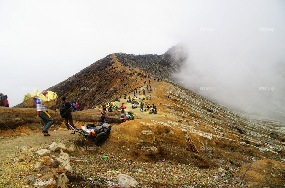 Sulfur miner and some tourist in mount ijen,  Indone