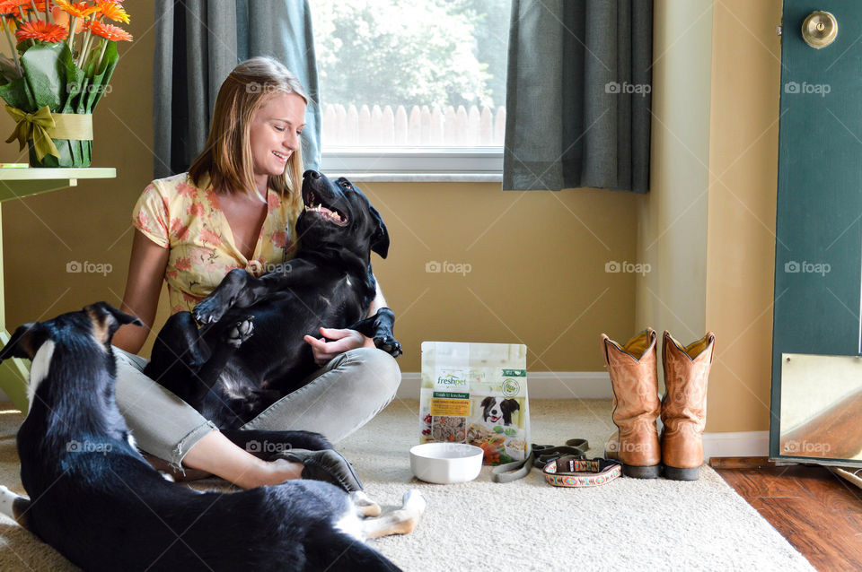 Woman sitting on the floor with her dogs in a living room