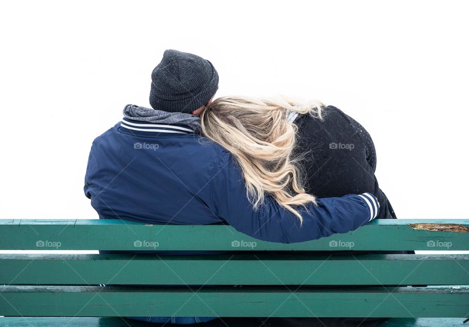 A female couple cuddles for a while on a park bench.
Calmness from the snow-covered ground and cold air around you.