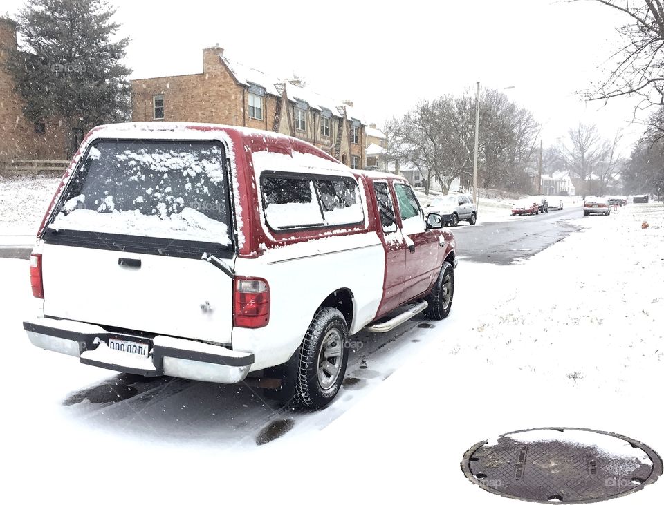 Red and white truck in snowy street scene