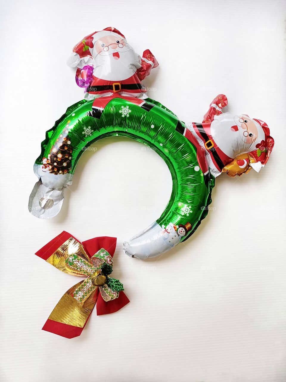 Santa Claus Christmas headband and Christmas bow on white background vertical composition.