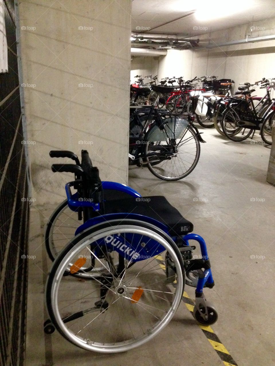 Parked wheelchair in the bicycle parking garage.