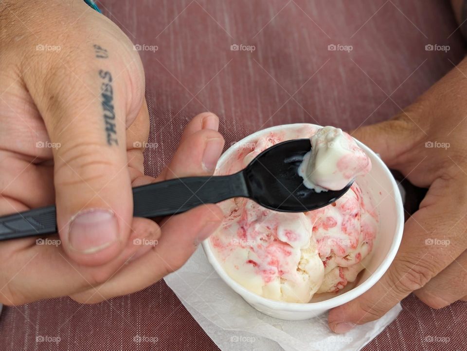 strawberry vanilla ice cream on a warm summer afternoon being enjoyed by a man with tattooed, working hands sexy contrast soft serve and hard hands