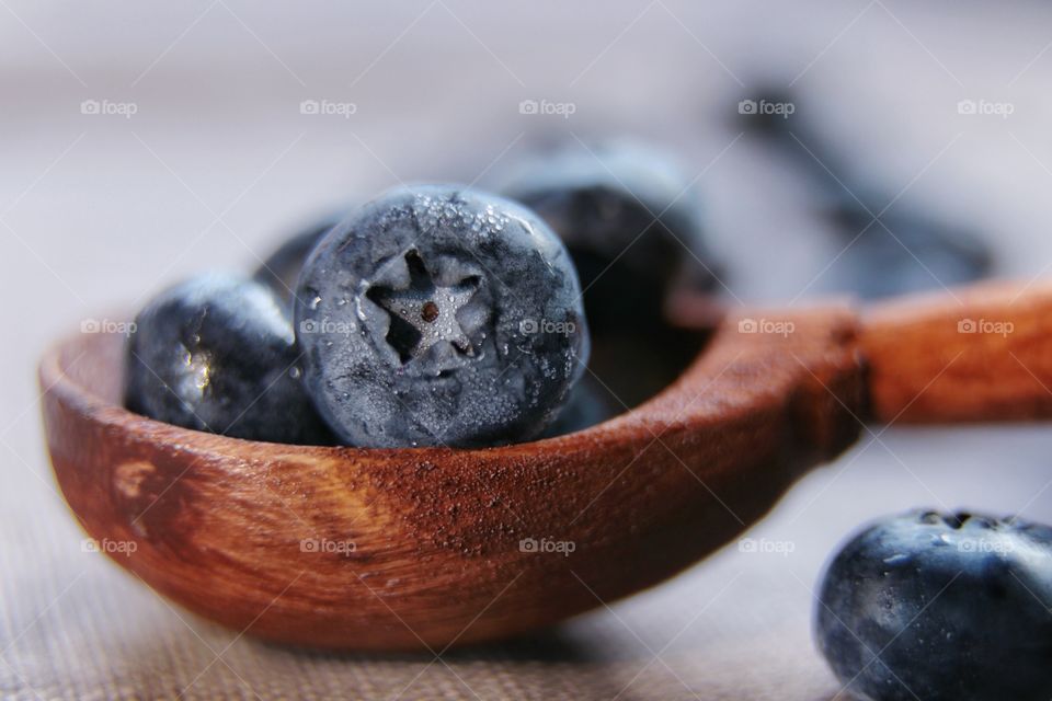 Fresh blueberries in a wooden spoon 