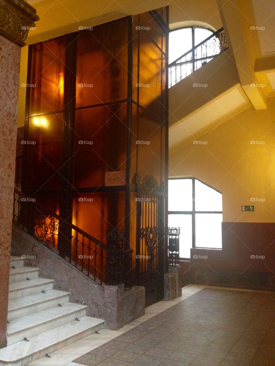 En elevator cabin of yellow glass in the historic building in Budapest