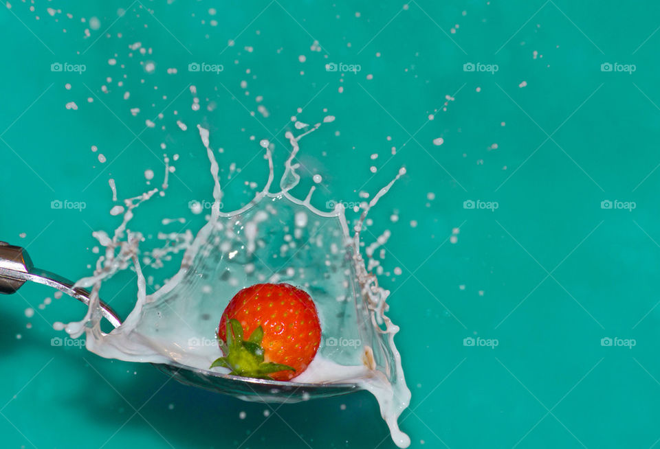 Strawberry being dropped onto spoon full of milk. Took 88 photos