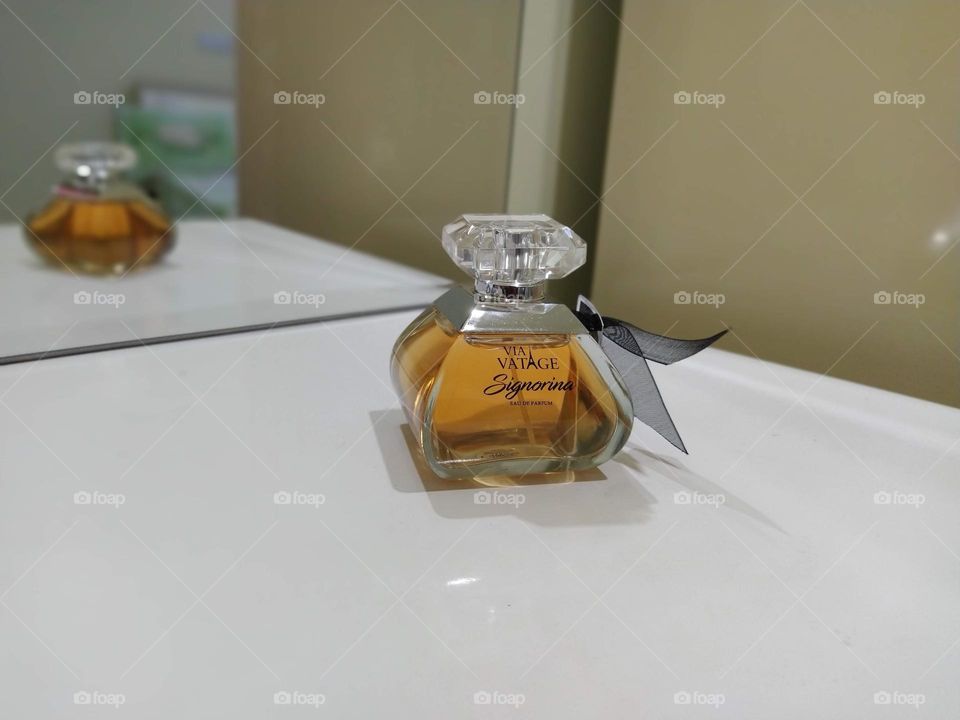 branded perfumes on a glass container on table