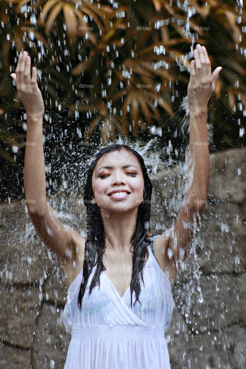 Close-up of a woman under waterfall