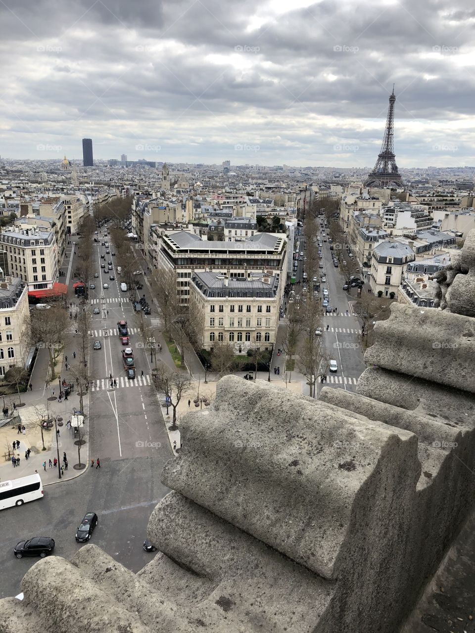 A view of the Paris streets from a top the Arc de Triumph, featuring the Eiffel Tower in the background. 