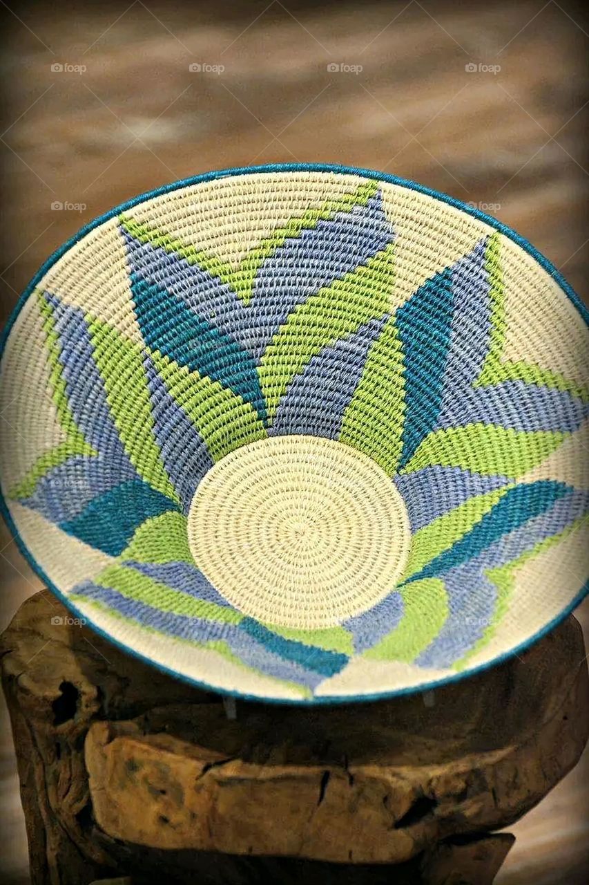 The image shows a group of hand -made dishes of wicker, decorated with colored embroideries with beautiful floral shapes, and is elegantly displayed in a warm corner that combines heritage and beauty, which gives the place an artistic spirit and attr