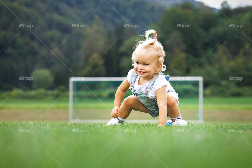 Little curly-haired girl on the football field
