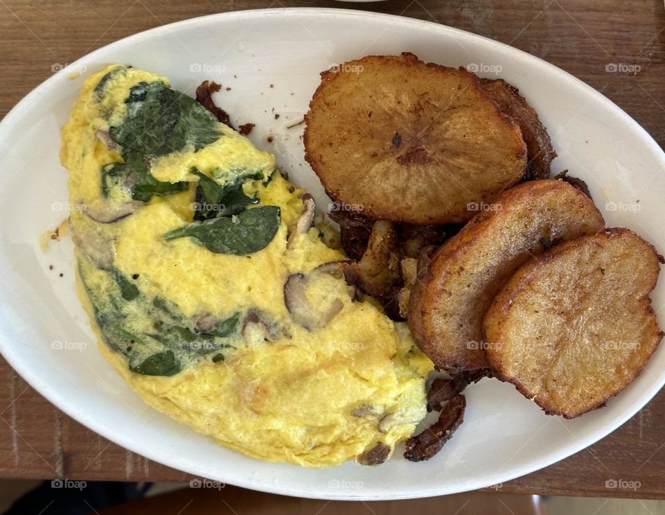 Five egg omelette with spinach and large homemade potatoes - Food nourishes us, delights us, and generally fuels our daily lives