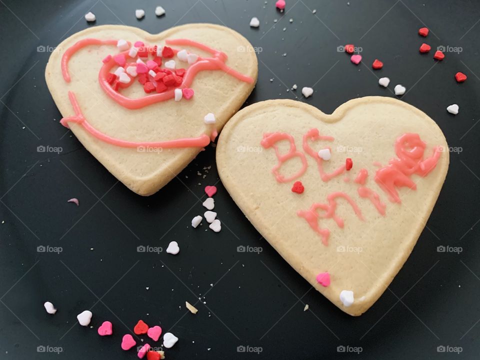 Sugar cookies with pink and red frosting decorated for Valentine’s Day. 