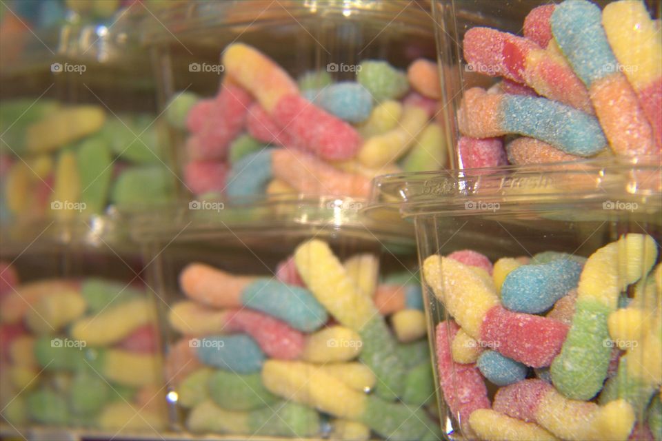 Sour Sugar Covered Gummy Worms In Stacked Plastic Containers
