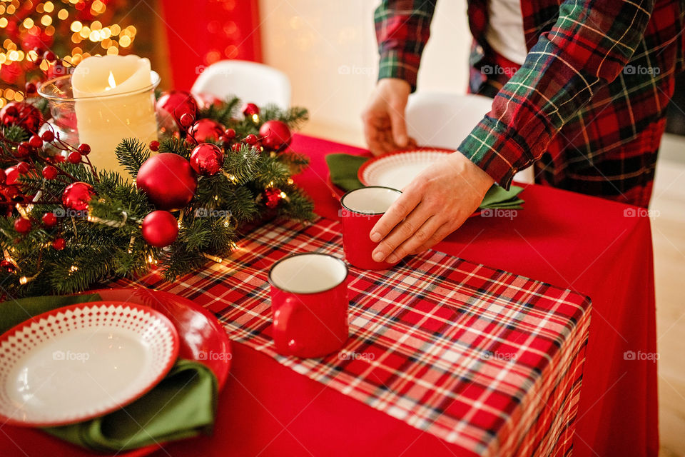 man sets a beautiful decorated winter table for a festive dinner.  Merry Christmas and Happy New Year.